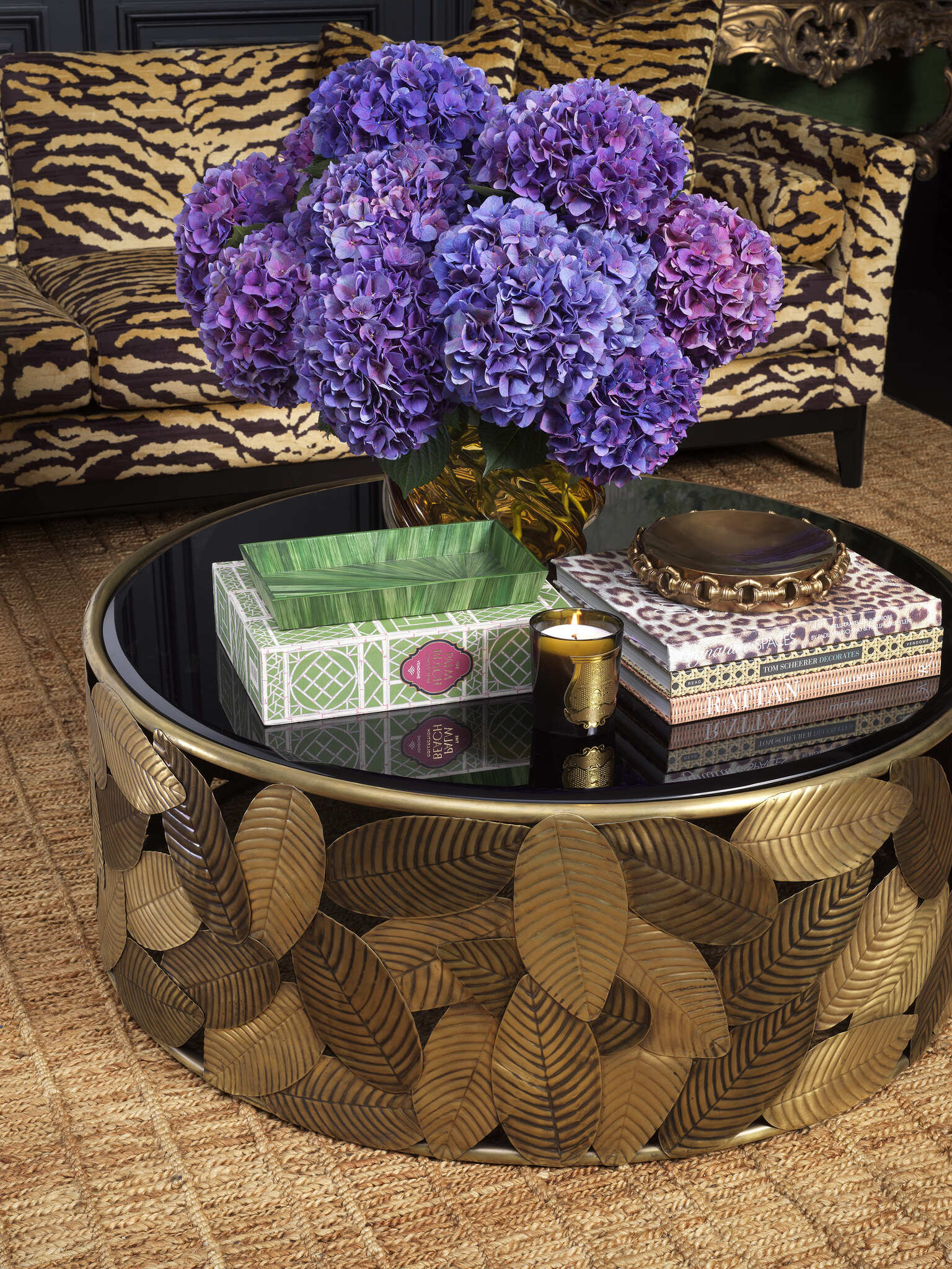 Luxuriöse Eichholtz Einrichtung mit Dschungel Chic Stil: Tigerfell-Sofa, goldene Akzente, grüne Accessoires, elegante Kronleuchter und exklusive Wandtapeten für ein exklusives Interieur.
