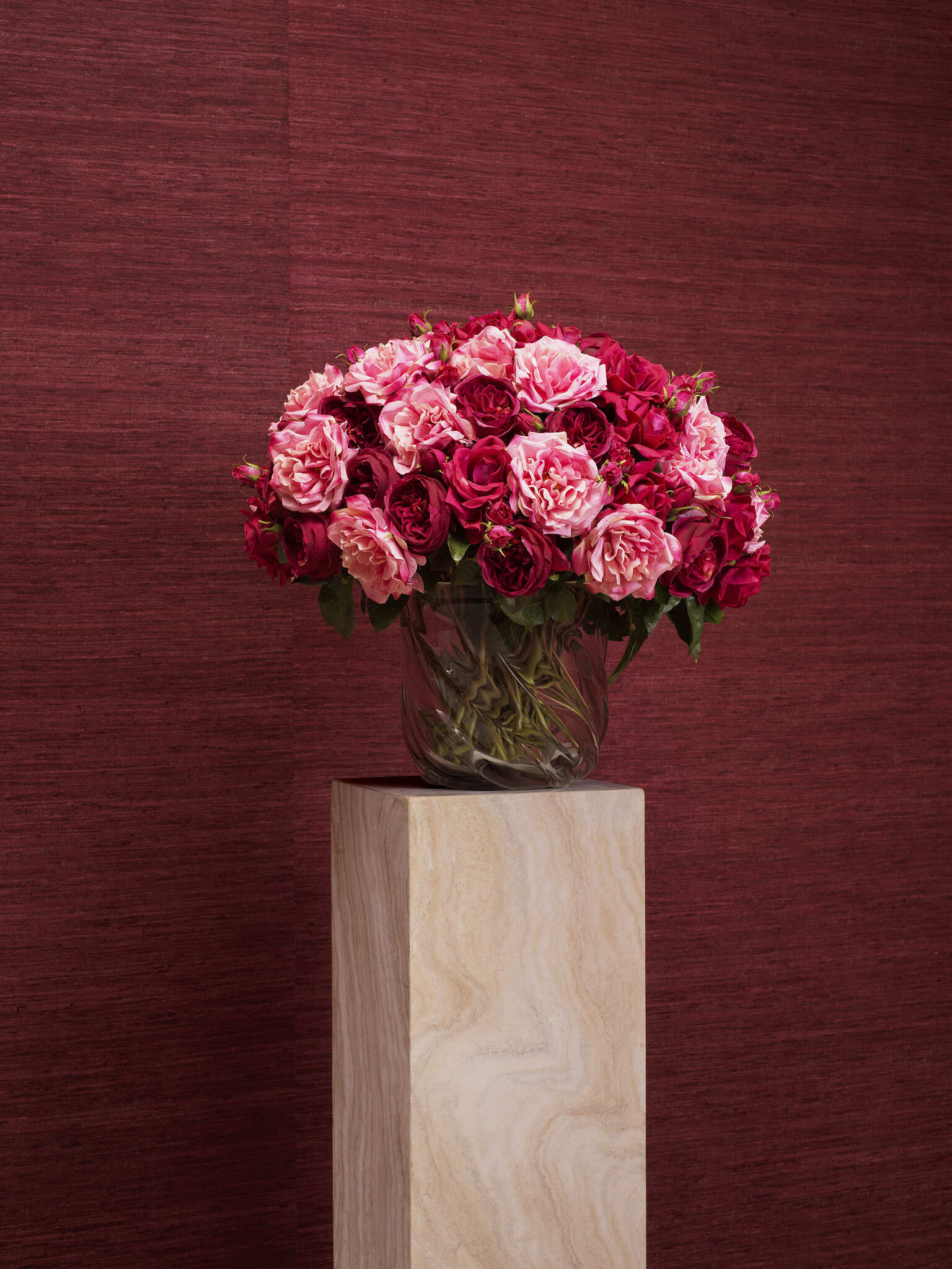 Elegante Wohnraumgestaltung mit rubinroten Wänden, luxuriösen schwarzen Vitrinen, modernen Sesseln und einem stilvollen Essbereich. Warme Beleuchtung durch Kronleuchter und Tischlampen, kombiniert mit hochwertigen Möbeln und dekorativen Accessoires für eine zeitlose und edle Atmosphäre.