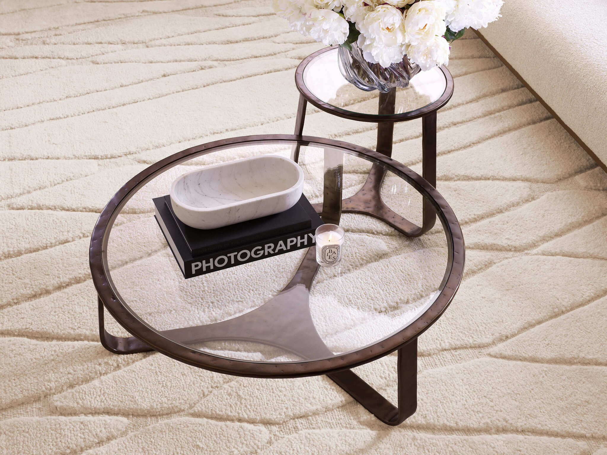 Luxuriöse Eichholtz Interior Design Kollektion Januar 2025 mit eleganten Möbeln, stilvollen Dekorationen, Glasvasen mit weißen Blumen und modernen Beleuchtungselementen in einem warmen, harmonischen Wohnambiente.