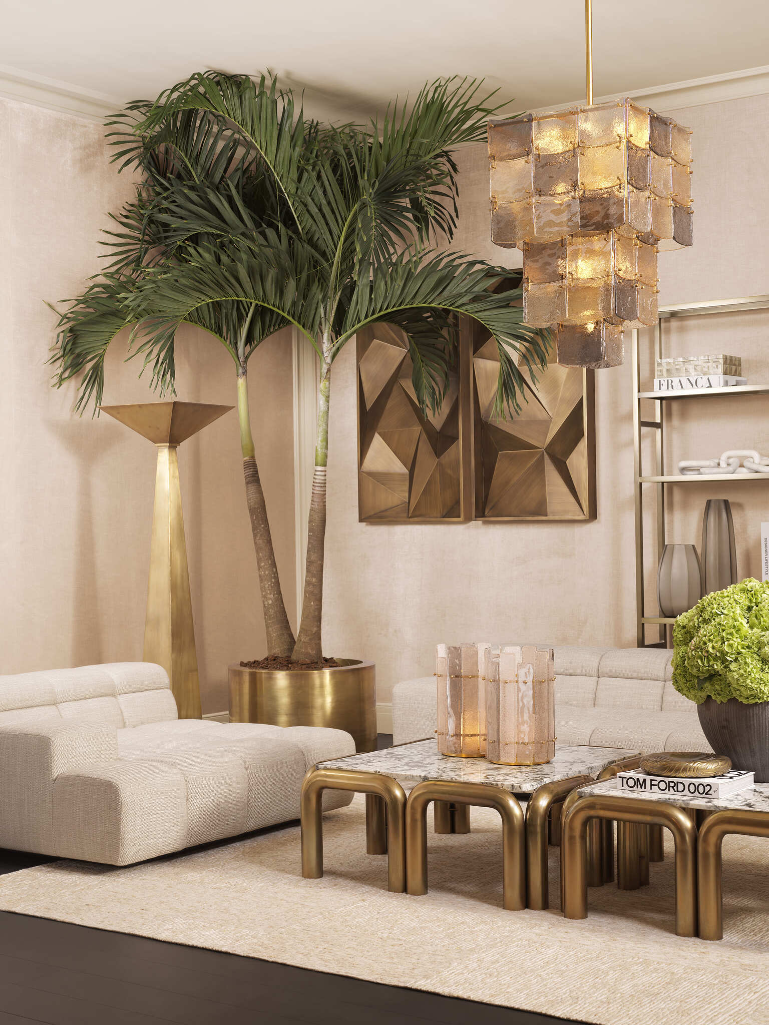 Elegante Wohnzimmereinrichtung mit cremefarbenen Sofas, goldfarbenen Beistelltischen mit Marmorplatten, modernen Lampen und stilvollen Dekorationen in warmen Naturtönen.