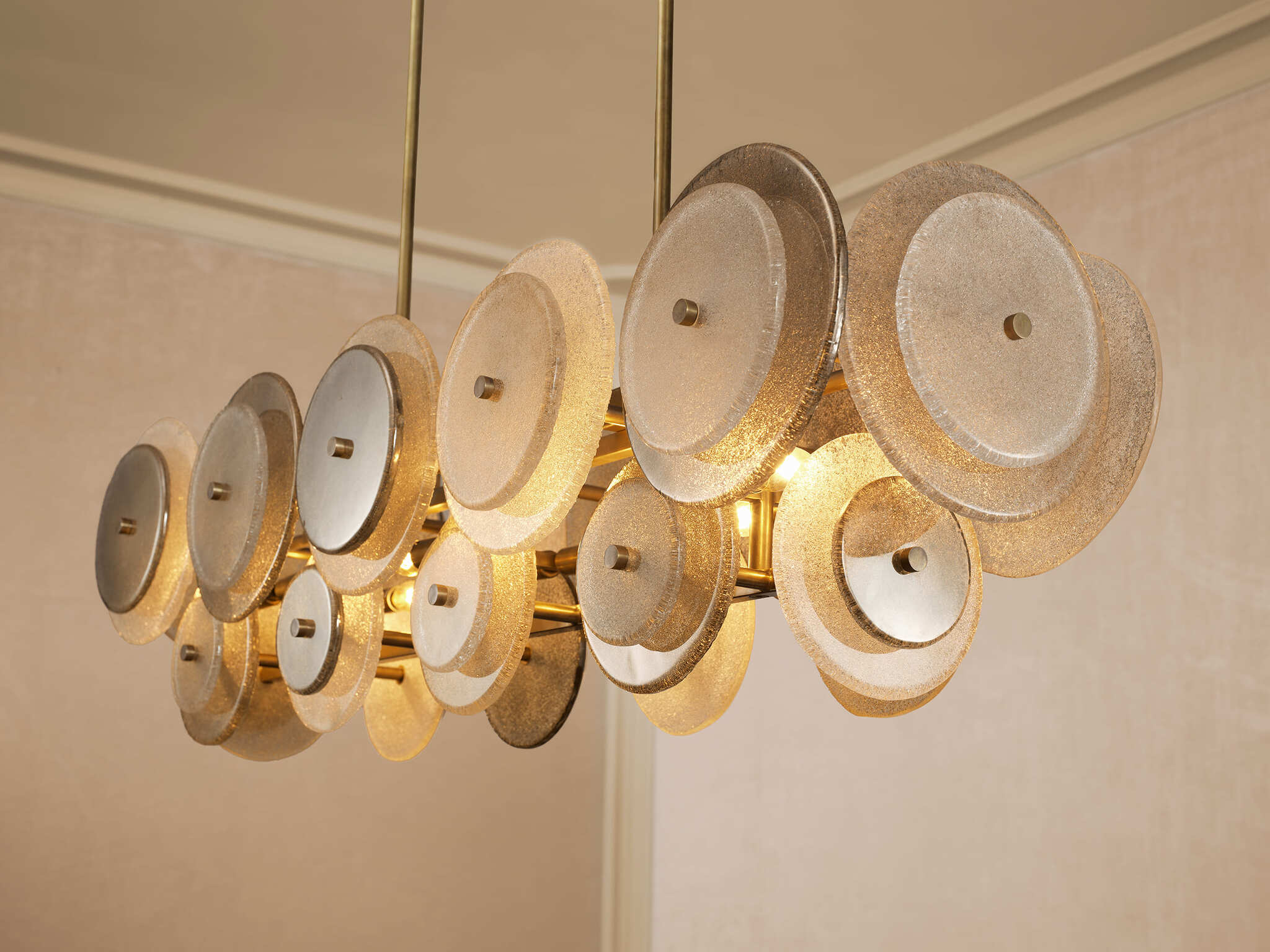 Elegante Wohnzimmereinrichtung mit cremefarbenen Sofas, goldfarbenen Beistelltischen mit Marmorplatten, modernen Lampen und stilvollen Dekorationen in warmen Naturtönen.